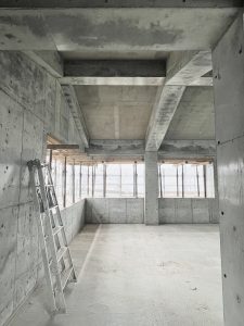 京都府左京区、出町柳駅から徒歩圏内に2024年6月にオープンするシェアオフィス、シェアハウス、カフェなどが併設された複合ビル「Whatever SHIMOGAMO EAST」の建設中の３階部分の高い天井